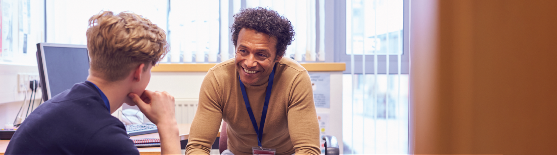 Counselor talking to a student in his office with a smile