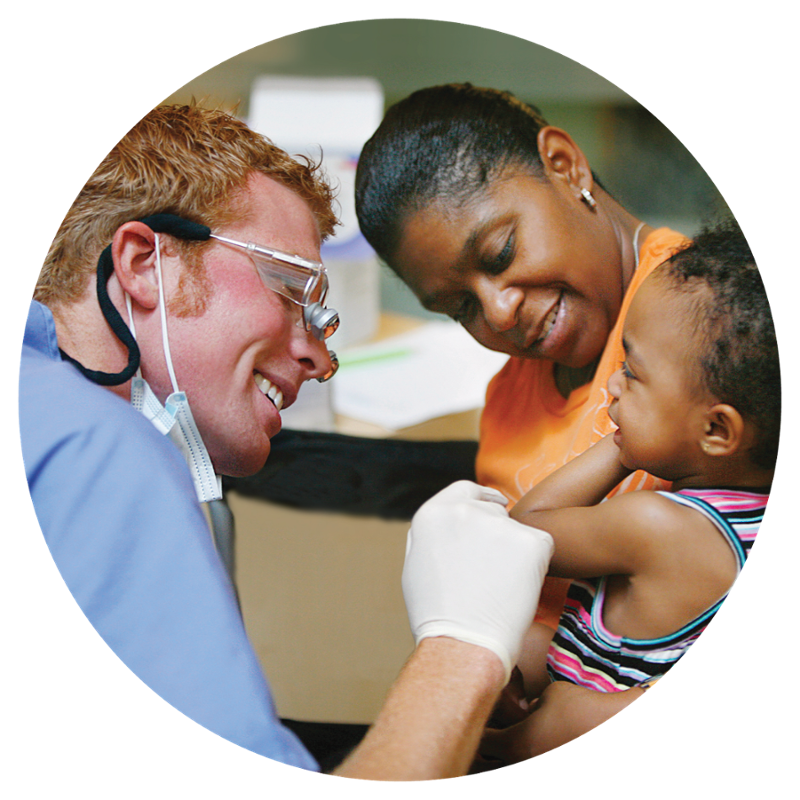 NSU doctor smiling with a mother and toddler son in the clinic