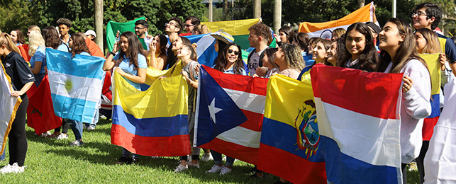 Students holding up various country flags