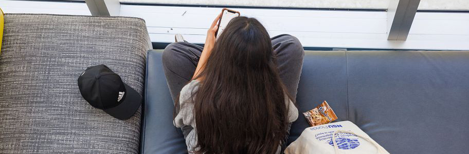 An overhead shot of an NSU student using their phone