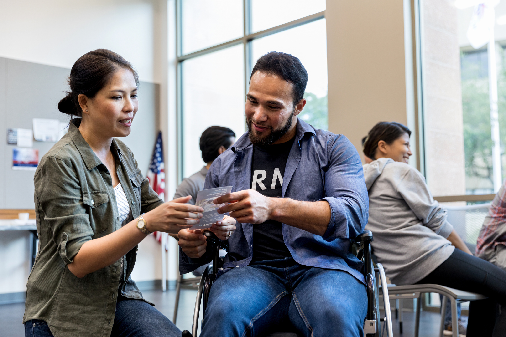 Mid adult woman and army vet in wheelchair review handout